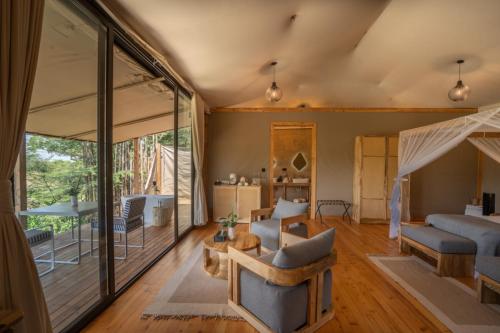 a living room with sliding glass doors and a living room with furniture at Olkupelia Mara in Talek