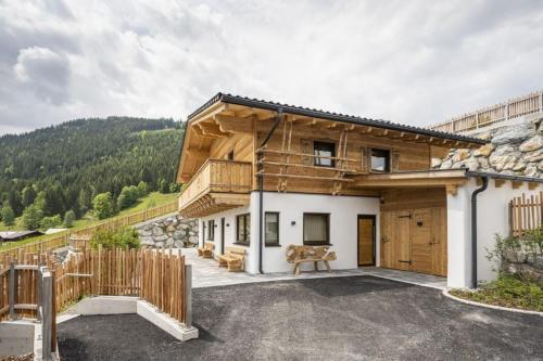 a house in the mountains with a wooden facade at AAF - Comfort Chalet Bergzeit in Forstau