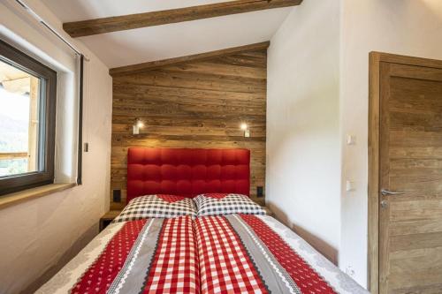 a bed in a room with a red headboard at AAF - Comfort Chalet Bergzeit in Forstau