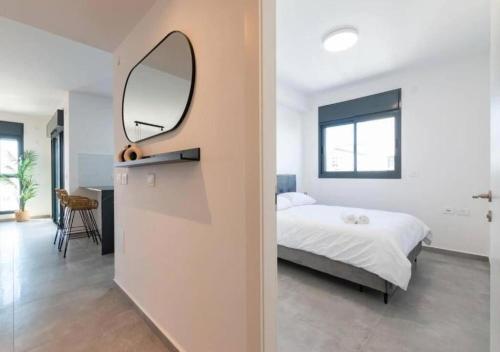 a bedroom with a bed and a mirror on a wall at O&O Group - Luxury APT/3 BR/New Tower/Parking in Or Yehuda