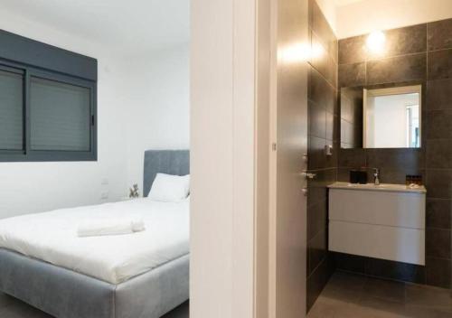 a bedroom with a bed and a bathroom with a mirror at O&O Group - Luxury APT/3 BR/New Tower/Parking in Or Yehuda