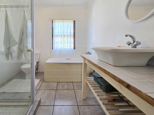 un bagno con lavandino, vasca e WC di Coastal Retreat a East London