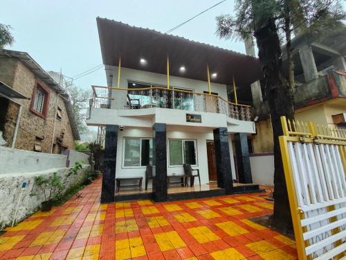a house with a balcony on top of it at Radiant villa in Panchgani
