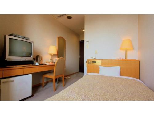 a hotel room with a bed and a desk with a television at Hotel Symphony - Vacation STAY 37099v in Sagae