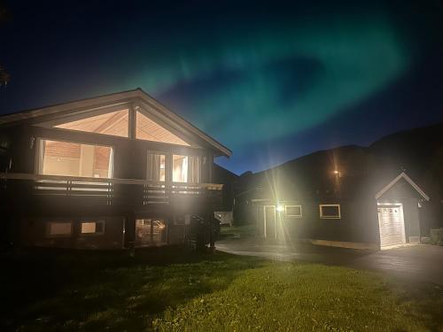 a house at night with the lights on at Kaldfjord Aurora Aparments New in Tromsø