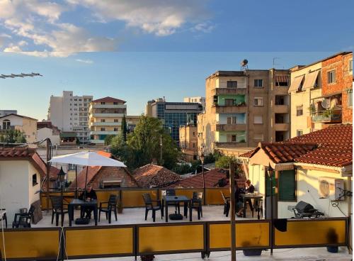 a balcony with tables and chairs and buildings at Cheap & Good by Topo in Tirana
