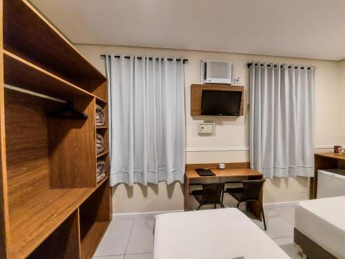 a hotel room with a desk and a bed and a tv at Hotel Itamarati Centro-República in Sao Paulo