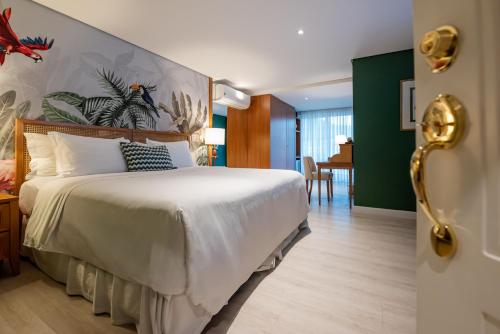 a bedroom with a large bed and a dining room at Villa do Vale Boutique Hotel in Blumenau