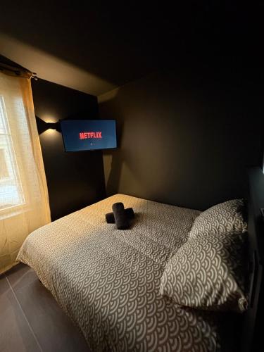 a bedroom with a bed with a television on the wall at La Romantique in Bressuire