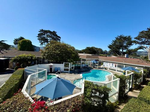 an overhead view of a swimming pool with an umbrella at Monterey Bay Lodge in Monterey