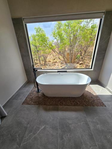 a bath tub in a bathroom with a large window at 19 on Idwala, Mabalingwe Game Reserve in Warmbaths
