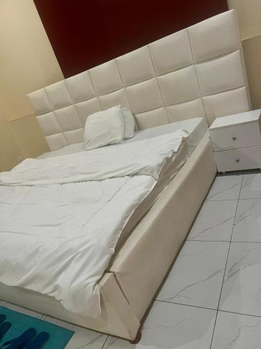 a white bed with a white headboard in a room at KIGALi VIEW HOMES & SUITES in Kigali