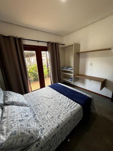 a bedroom with a bed and a large window at Ape beira-mar paraiso kitesurf in Cajueiro