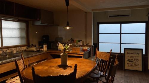 a kitchen with a wooden table with chairs and a table sidx sidx sidx at Oyado Dokumasu - Vacation STAY 33206v in Furano