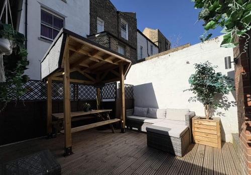 a gazebo and a couch on a patio at Coastal Comfort Seaside Cabin with Spacious Garden in Margate