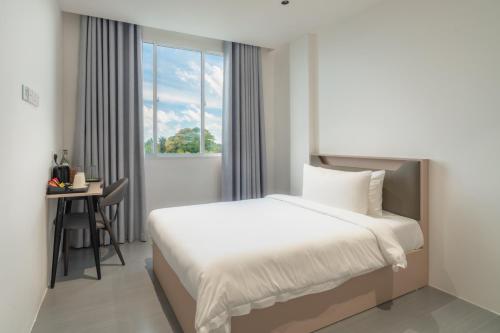 a bedroom with a bed and a desk and a window at Nest by Hawks Hotels Kamadhoo Baa Atoll in Kamadhoo