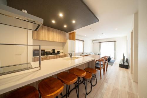 a kitchen with a bar with wooden stools at Ume no Yu Moonlight - Vacation STAY 42183v in Dazaifu