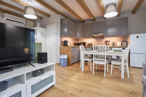a kitchen with a dining room table and a television at Bodza apartman 2 - Sarud in Sarud