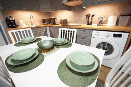 a kitchen with a table with green dishes on it at Bodza apartman 2 - Sarud in Sarud