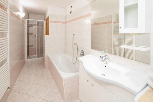 Un baño con bañera, lavabo y bañera. en CASA ARNEIRA, en Livigno