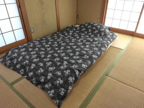 a bed with a black blanket on the floor at Townhouse No, 3 - Vacation STAY 43084v in Sanuki