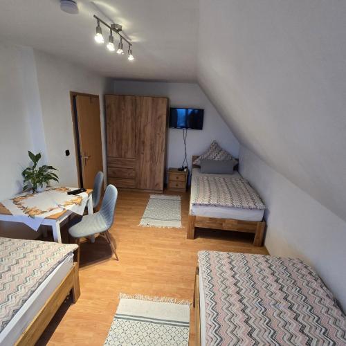 a attic room with two beds and a table at Lauterhofen Haus 8 in Lauterhofen