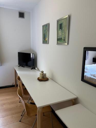 a white desk with a computer and two chairs at Egtved Hotel in Egtved