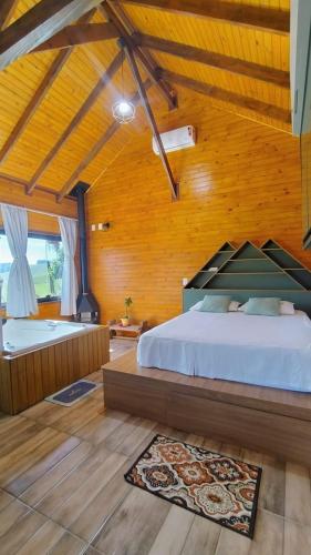 a bedroom with a bed and a tub in a room at Chico Cabanas in Lajeado Grande