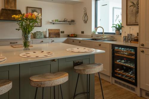 a kitchen with a center island with stools at Trelawney in Yelverton