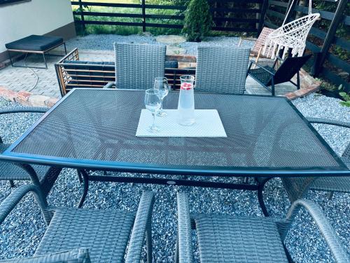 a glass table with two glasses and a bottle at Casa Hardic in Horodnic de Sus