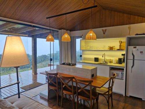 ランショ・ケイマードにあるTiny House em Taquaras, Rancho Queimadoのテーブルと椅子と冷蔵庫のあるキッチン