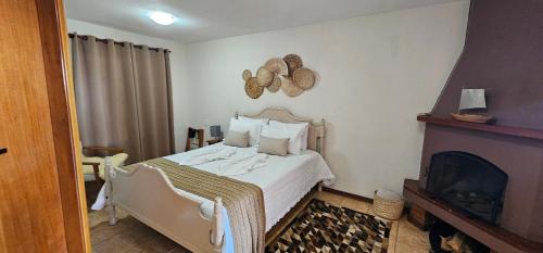 a bedroom with a bed and a fireplace at Pousada Flor de Lua Monte Verde in Monte Verde