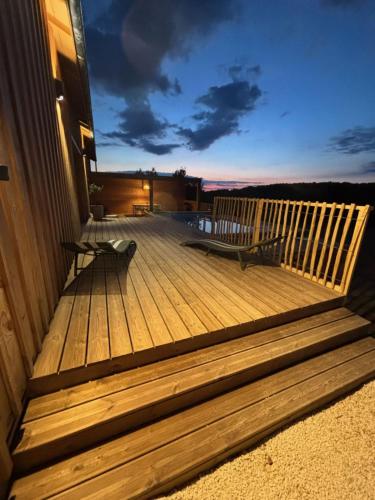 a wooden deck with a bench on the side of a house at Vignes du Roc in Rayet