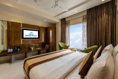 a hotel room with a bed and a television at Hotel Grand Plaza in City Centre - Walking Distance From New Delhi Railway Station and Connaught Place in New Delhi