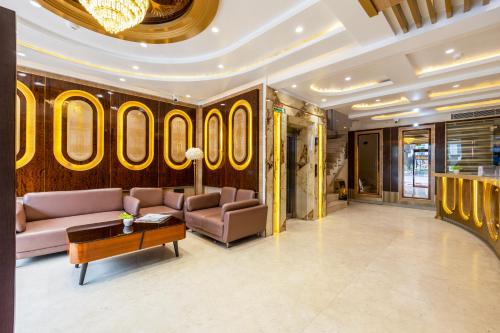 a lobby with couches and a table in a building at Hotel Grand Plaza in City Centre - Walking Distance From New Delhi Railway Station and Connaught Place in New Delhi