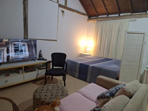 a living room with a couch and a bed at Loft charmoso! in Água Boa