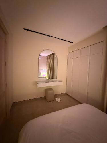 a bedroom with a white bed and a mirror at سكون للاجنحة الفندقية in Baghdad