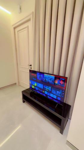 a flat screen tv sitting on a black stand in front of a window at سكون للاجنحة الفندقية in Baghdad