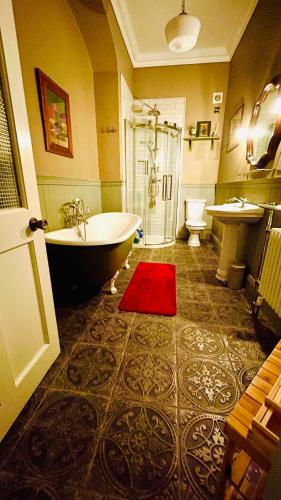 a bathroom with a tub and a sink and a toilet at Lissanisky House in Ballymackey