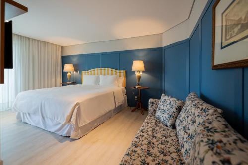 a hotel room with a bed and a couch at Villa do Vale Boutique Hotel in Blumenau