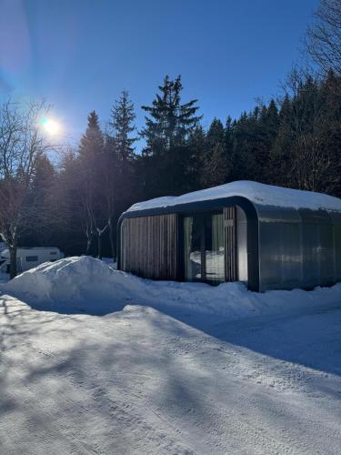 a building sitting on top of a pile of snow at Chalets & Apartments - Base Camp Medvědín in Špindlerův Mlýn