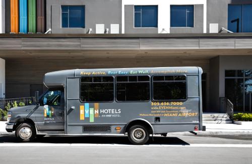 a bus parked in front of a building at EVEN Hotel Miami - Airport by IHG in Miami