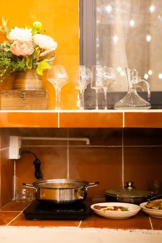 a kitchen counter with glasses and a pot on a stove at Sunrise Room in Ngân Hà