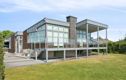 a house with a glass facade with a lawn at 4 Bedroom Lovely Home In Hadsund in Øster Hurup