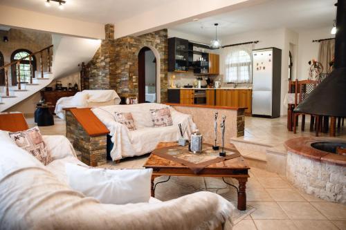 Una sala de estar con dos sofás y una mesa. en Olympus Leptokaria’s Luxurious Villa, en Leptokarya