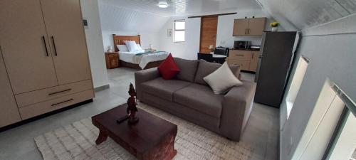 a living room with a couch and a room with a bed at Forest Hideaway in Knysna