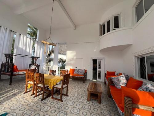 ein Wohnzimmer mit einem gelben Tisch und orangefarbenen Stühlen in der Unterkunft Mambrui Holiday Villa Nyumba Nane in Malindi