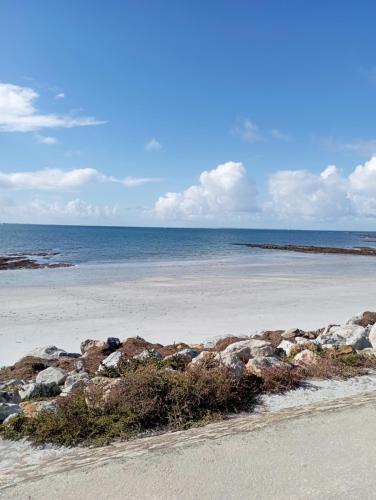 a beach with rocks and the ocean in the background at mobil-home bord de plage in Sarzeau