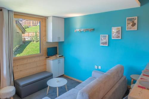 a living room with a couch and a window at Studio cabine vue montagne au pied des pistes & commerces in Avoriaz