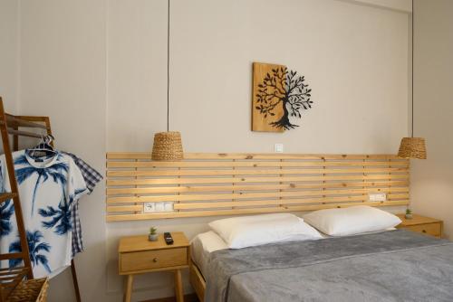a bedroom with a bed with a wooden headboard at Cestrum Suites in Agios Nikolaos